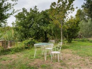 a table and chairs in a yard with a tree at Apartment Casale Ai Noccioli-2 by Interhome in Corchiano