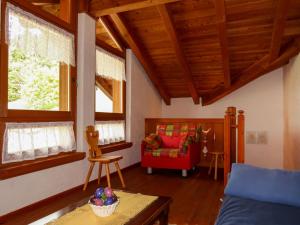 a living room with a couch and a red chair at Apartment Maso Marini - Appartamento Cervo by Interhome in Santa Giuliana