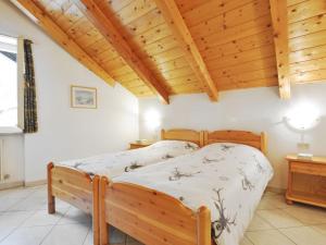 un letto in una stanza con soffitto in legno di Apartment Villa Placidia Apt 33 by Interhome a Campitello di Fassa