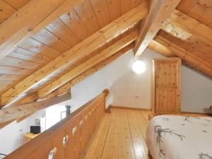 una camera da letto mansardata con soffitti in legno e un letto di Apartment Villa Placidia Apt 33 by Interhome a Campitello di Fassa