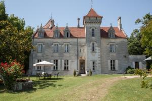 an old castle with a table in front of it at Château des Salles in Saint-Fort-sur-Gironde