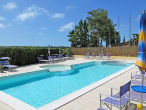 una piscina con sedie e ombrelloni in un resort di Apartment Riviera 7 by Interhome a Marina di Cecina