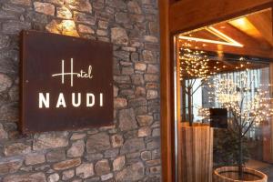 a sign on the side of a brick wall at Hotel Naudi Boutique Adults only in Soldeu