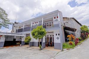 - un vieux bâtiment blanc avec un balcon dans l'établissement SUPER OYO 90405 Penginapan Sasti Kuningan, à Cirebon