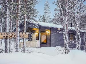 uma cabana de madeira na floresta na neve em Holiday Home Pikkuporo a by Interhome em Saariselka