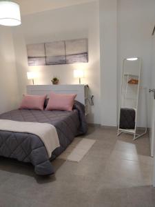 a bedroom with a bed with pink pillows and a ladder at Casa Guanche in Puerto del Rosario