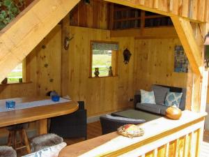 una cabaña de madera con un sofá y una mesa en Apartment Ferienwohnung Gurkhof 2 - Gurk by Interhome, en Gnesau