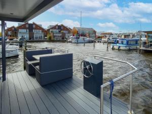 a dock with a bench and boats in the water at Holiday Home De Meerparel-1 by Interhome in Uitgeest