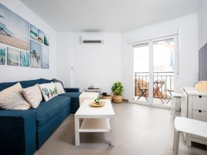- un salon avec un canapé bleu et une table blanche dans l'établissement Apartment Amelie by Interhome, à Nerja