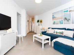 un salon avec un canapé bleu et une télévision dans l'établissement Apartment Amelie by Interhome, à Nerja