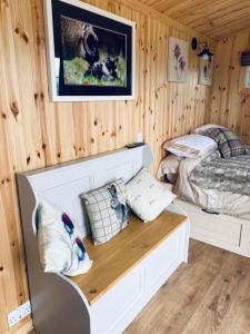 a bedroom with two beds and a wooden wall at Remarkable Shepherds Hut in a Beautiful Location in Perth