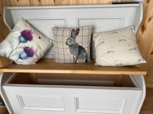 a shelf with pillows and a rabbit sitting on it at Remarkable Shepherds Hut in a Beautiful Location in Perth
