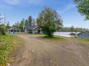 een huis aan de kant van een weg naast een meer bij Holiday Home Villa leinola 2 by Interhome in Puhos