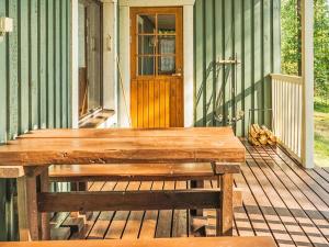 eine Holzbank auf der Veranda eines Hauses in der Unterkunft Holiday Home Hauki by Interhome in Hiukkajoki + 19 Fotos