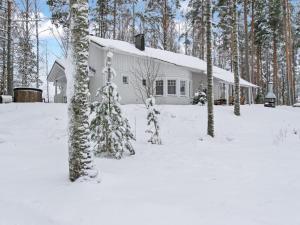 a white house in the snow with trees at Holiday Home Siika by Interhome in Hiukkajoki