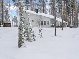 een wit huis in de sneeuw met bomen bij Holiday Home Siika by Interhome in Hiukkajoki