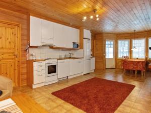 een keuken met witte kasten en een eetkamer met een tafel bij Holiday Home Siika by Interhome in Hiukkajoki +19 foto's