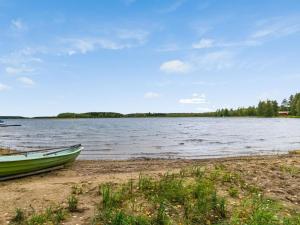 een groene boot aan de oever van een meer bij Holiday Home Siika by Interhome in Hiukkajoki