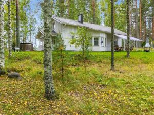een wit huis midden in een bos bij Holiday Home Siika by Interhome in Hiukkajoki
