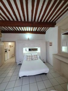 1 dormitorio con cama blanca y techo de madera en Suite parentale Castillon du Gard, en Castillon-du-Gard