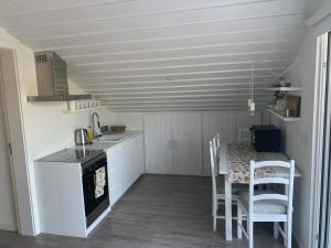 a kitchen with a table and a kitchen with white cabinets at Lovely 2-bedroom apartment- Comporta in Carvalhal