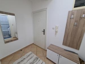 a white room with a door and a mirror at Apartman Central in Bijeljina