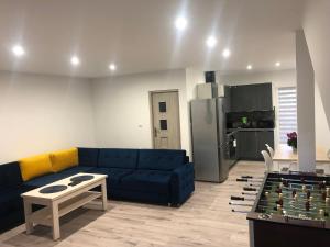 a living room with a blue couch and a table at Apartament Telkom 1 in Milówka