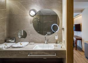 a bathroom with a sink and a mirror at Falkensteiner Family Hotel Sonnenalpe in Sonnenalpe Nassfeld
