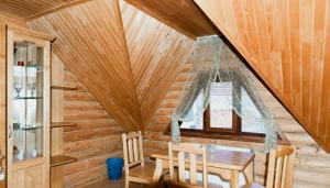 a dining room with a wooden ceiling and a table at Шепіт Карпат in Pilipets