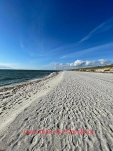 a beach with footprints in the sand and the ocean at Kuscheliges Sylt Zuhause für 2 Personen in Westerland (Sylt)