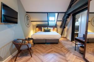 1 dormitorio con 1 cama, TV y silla en Alex Maastricht, en Maastricht
