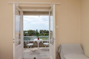 a bedroom with a bed and a table and a balcony at Studio Maha in Dubrovnik