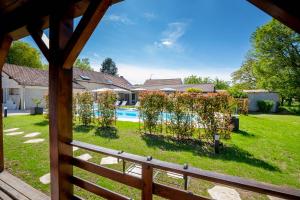 uma vista para um pátio com uma cerca e uma piscina em B&B L'Orée du Bois Bourgogne - Adults Only em Saint-Nicolas-lès-Cîteaux