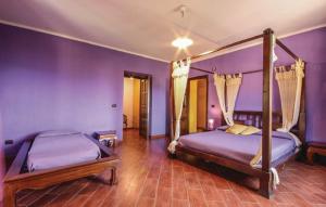 two beds in a bedroom with purple walls and wooden floors at Palazzo Conforti Tree House Resort in Marano Marchesato