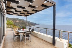 a balcony with a table and chairs and the ocean at VILLA KATERINA Arkadian village in rkadiko Chorio