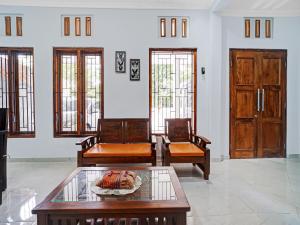 a living room with two chairs and a table at RedDoorz at Omah Candi Sari near Airport YIA in Yogyakarta