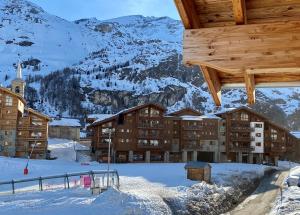 un complexe dans la neige avec des montagnes en arrière-plan dans l'établissement Chalet Carte Blanche Merveilles, à Tignes