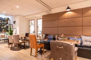 een restaurant met tafels en stoelen en een bank bij Hotel Restaurant "Molenzicht" in Nes