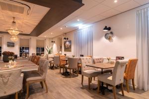 une salle à manger avec des tables et des chaises en bois dans l'établissement Hotel Restaurant "Molenzicht", à Nes