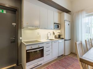 a kitchen with white cabinets and a sink and a refrigerator at Holiday Home Levin stara a04 by Interhome in Sirkka