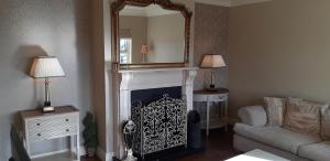 a living room with a fireplace and a mirror at Relax at Safe Haven in Carlingford