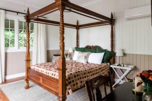 Mount Glorious的住宿－Maiala Park Lodge，一间卧室,卧室内配有一张天蓬床