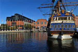a large boat docked in the water near a city at Quality Hotel 11 & Eriksbergshallen in Gothenburg
