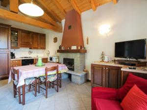eine Küche mit einem Tisch, einem TV und einem Kamin in der Unterkunft Apartment Ghiano by Interhome in Cremia