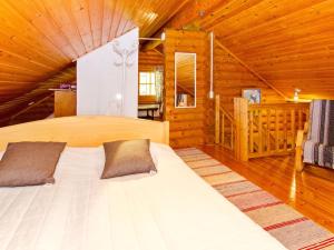 a bedroom with a bed in a wooden cabin at Holiday Home Suvituuli by Interhome in Liperi