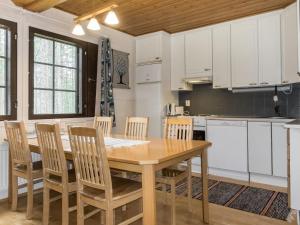 a kitchen with a wooden dining table and chairs at Holiday Home Kevinlevi by Interhome in Sirkka