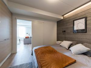 1 dormitorio con 1 cama grande y pared de madera en Holiday Home Skisuite 310 by Interhome en Sirkka