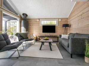 a living room with a couch and a tv at Holiday Home Aurinkoranta by Interhome in Padasjoki