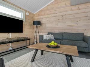 a living room with a couch and a table with a bowl of fruit at Holiday Home Aurinkoranta by Interhome in Padasjoki