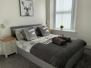 a bedroom with a large bed with a night stand at Deeside Snugs Apartments in Kincardine OʼNeil